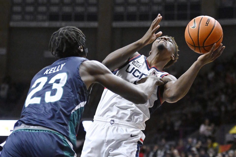 UNC Wilmington forward Amari Kelly (23) fouls Connecticut's Nahiem Alleyne during the first half of an NCAA college basketball game Friday, Nov. 18, 2022, in Storrs, Conn. (AP Photo/Jessica Hill)