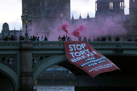 Demonstrators unfurl a banner from Westminster Bridge, next to the Houses of Parliament, in London, Britain November 15, 2018. REUTERS/Simon Dawson