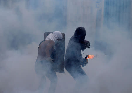 An opposition supporter throws a molotov cocktail during clashes with security forces at a rally against Venezuela's President Nicolas Maduro in Caracas, Venezuela, April 26, 2017. REUTERS/Carlos Garcia Rawlins