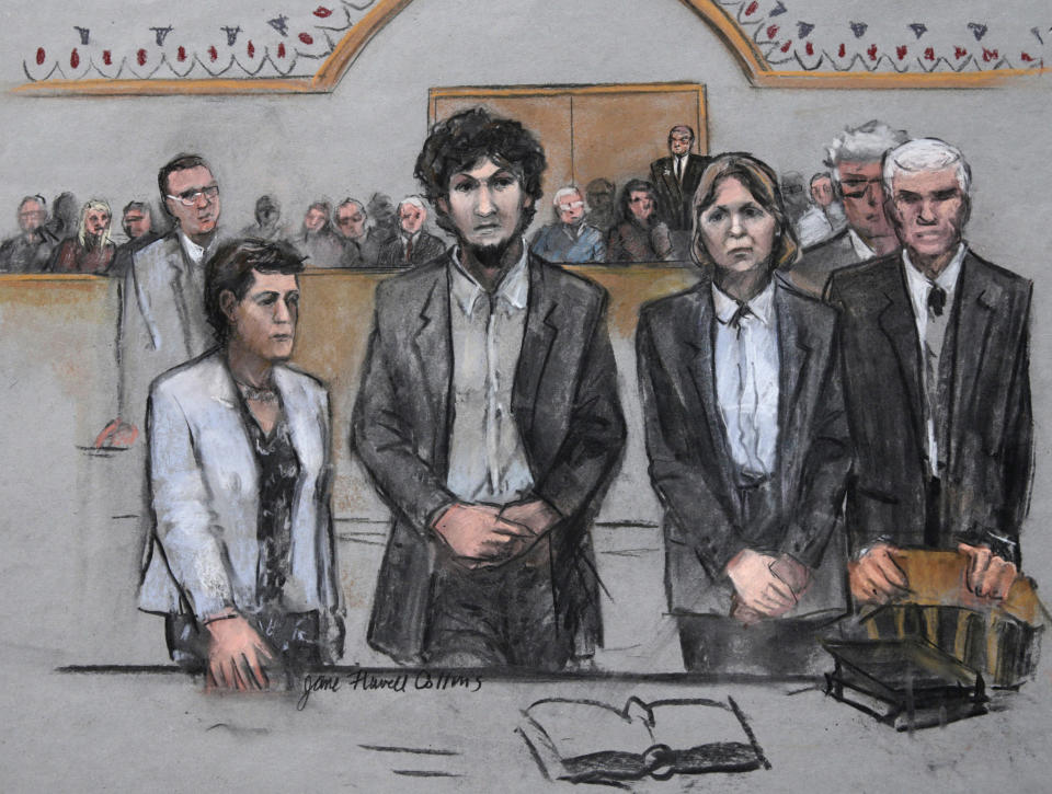 FILE— In this May 15, 2015 file courtroom sketch by Jane Flavell Collins, Boston Marathon bomber Dzhokhar Tsarnaev, center, stands with his defense attorneys as a death by lethal injection sentence is read at the Moakley Federal court house in the penalty phase of his trial in Boston. Collins, a courtroom sketch artist who drew pictures of defendants in some of the most notorious cases tried in federal court in Boston, died Sunday, May 16 2021, according to her family. She was 84. (Jane Flavell Collins via AP)