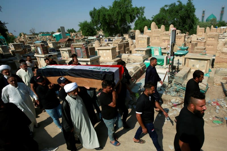 Mourners carry the coffin of a protester, who was killed at protests in Baghdad, during a funeral at a cemetery in the holy city of Najaf