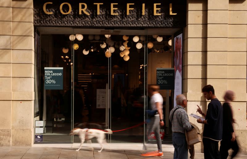 FILE PHOTO: Tourists and locals walk past a Cortefiel store in Barcelona