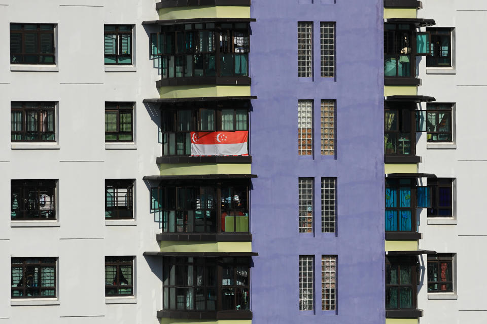 A resident displays the Singapore flag as a show of solidarity against the outbreak here on 12 May, 2020. (PHOTO: Getty Images)