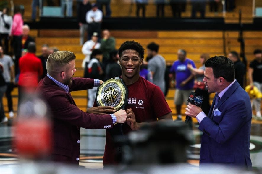 Iowa State wrestler David Carr, a former Perry High School standout who is a five-time state champion and a national champion, smiles while being interviewed by four-time national champion and Olympic bronze medalist Kyle Dake, left, and Shane Sparks after a dual with Cleveland State on Sunday at Perry.