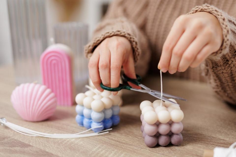 Woman trimming candle wick.