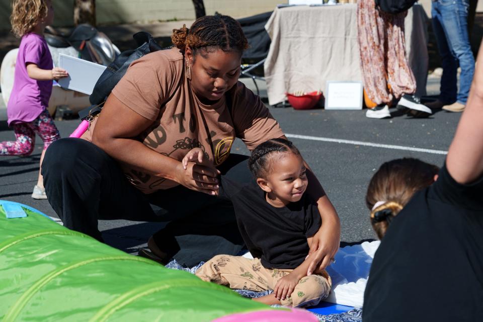 Brandy Welch helps son, Logan Welch, 2, participate in kid-friendly yoga at ESA Connection's Discover Enrichments! Educational Fair at Baker's MMA on Oct. 28, 2023, in Surprise, AZ.