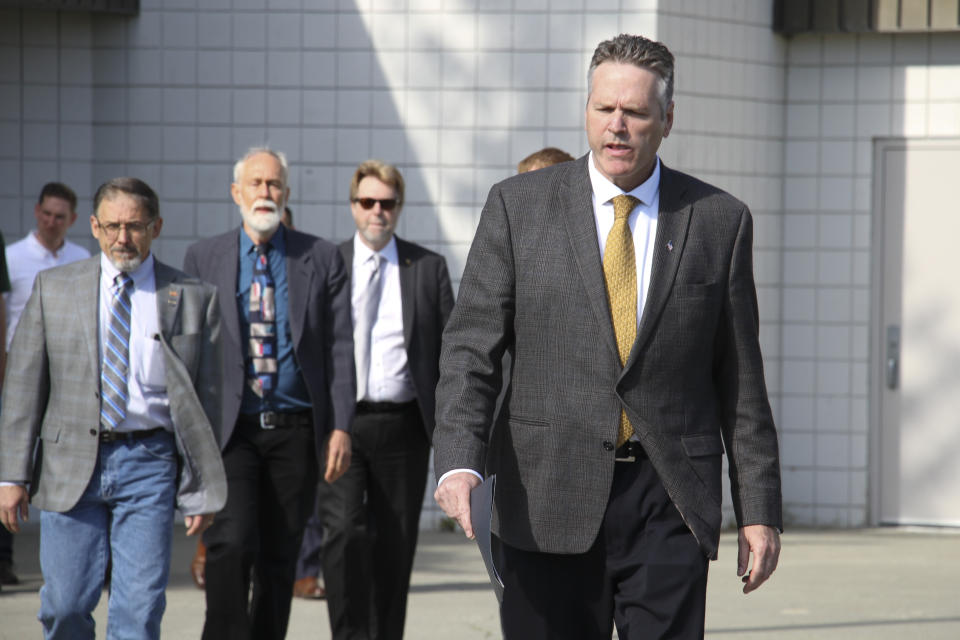 This June 14, 2019, photo shows Alaska Gov. Mike Dunleavy leading state and local officials out of Wasilla Middle School in Wasilla, Alaska, to a news conference. Dunleavy has called lawmakers into special session in Wasilla beginning July 8, but some lawmakers have expressed concerns over security and logistics with the location more than 500 miles from the state capital of Juneau, Alaska. (AP Photo/Mark Thiessen)