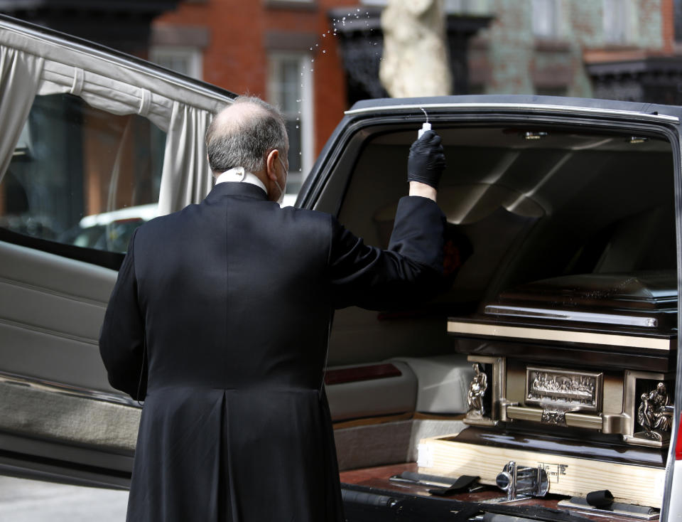 Monsignor Kieran Harrington, Vicar for Communications for the Diocese of Brooklyn, splashes holy water over the casket of the Rev. Jorge Ortiz-Garay in the Brooklyn borough of New York as they prepare to transport his body to John F. Kennedy International Airport on Sunday, May 3, 2020. At 49, Ortiz-Garay was the first Catholic cleric in the United States to die from the coronavirus outbreak. He will be laid to rest in his birthplace of Mexico City. (AP Photo/Jessie Wardarski)