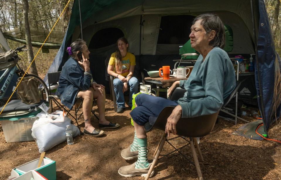 Eileen Augustino, who is disabled, sits outside with her niece Shannon Augustino and neighbor April Higgins and enjoy the warm weather at the homeless camp in the woods of Toms River.