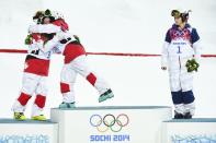 Third placed Hannah Kearney (R) of the U.S. watches as winner Canada's Justine Dufour-Lapointe embraces her second placed sister Chloe (L) during flowers ceremony after the women's freestyle skiing moguls final competition at the 2014 Sochi Winter Olympic Games in Rosa Khutor, February 8, 2014. REUTERS/Dylan Martinez (RUSSIA - Tags: SPORT OLYMPICS SPORT SKIING)