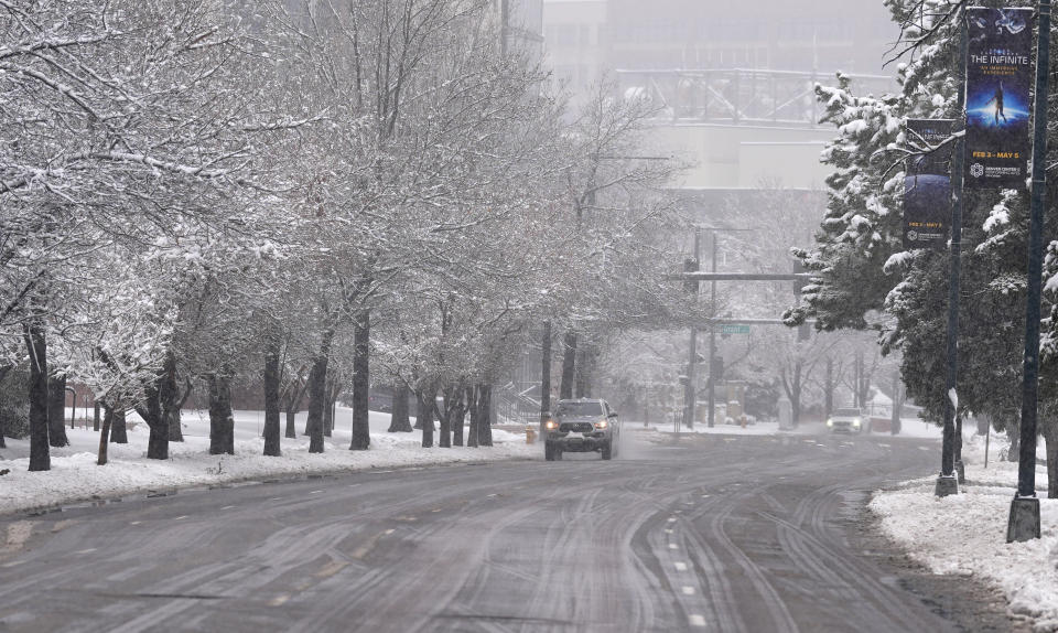 A lone vehicle moves eastbound along normally-conggested Speer Boulevard as a late winter storm dropped up to a foot of snow Thursday, March 14, 2024, in Denver. Forecasters predict that the storm will persist until early Friday, snarling traffic along Colorado's Front Range communities. (AP Photo/David Zalubowski)