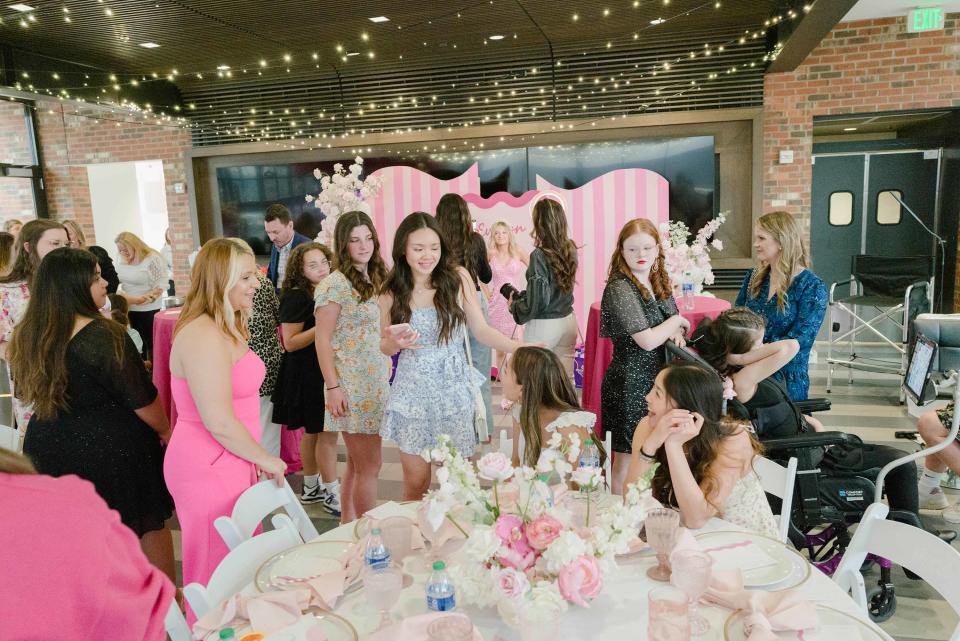 Evelyn's mom Alex (far left, in pink) greets guests.