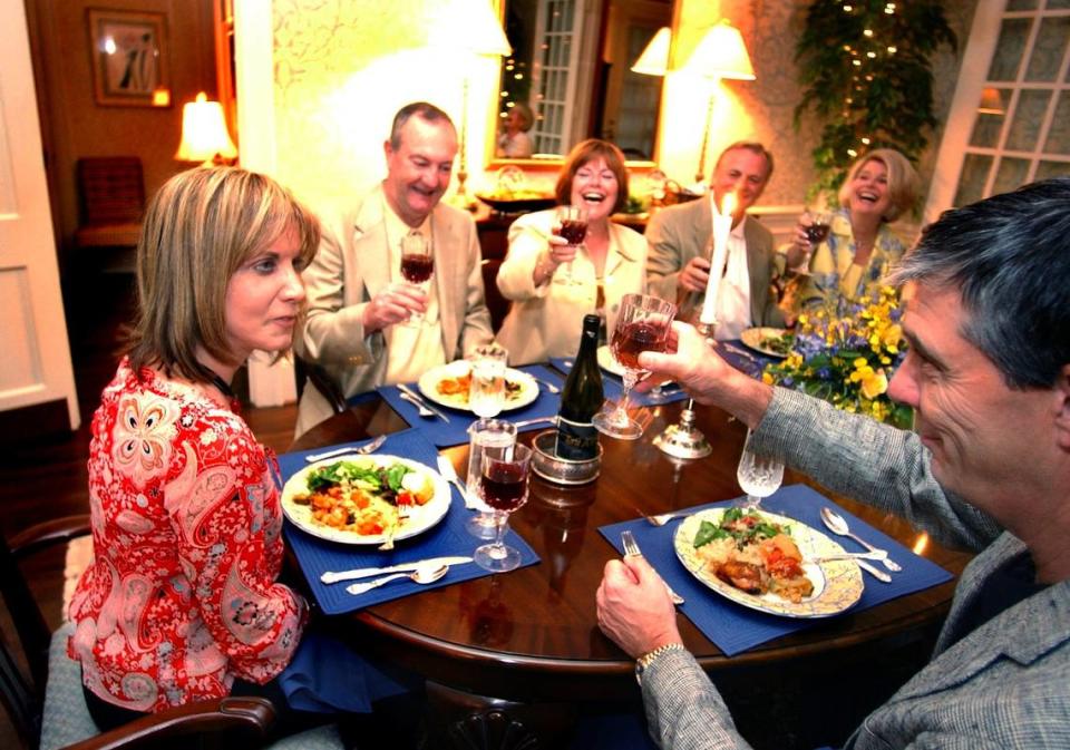 Host Lynn Wheeler gets a toast from her guests at a dinner party at her Charlotte home. TODD SUMLIN