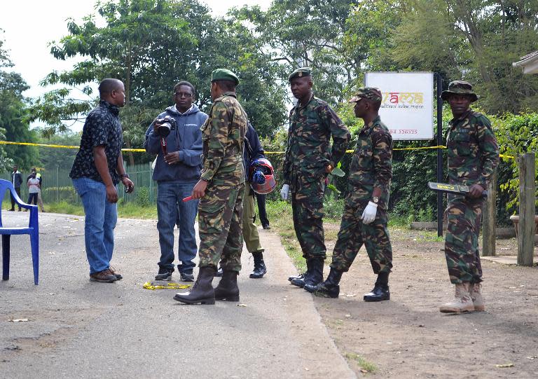 Police and journalists stand at the scene of a bomb attack on July 8, 2014 in Arusha, nothern Tanzania