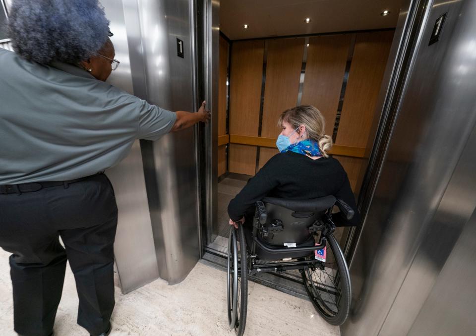 A Coleman A. Young Municipal building worker passing by, kindly holds the elevator door on Jan. 5, 2023, so Jill Babcock, 51, of Detroit, can make it in without the door closing on her. Babcock, a supervisory program analyst for the policy team for the city of Detroit is a plaintiff in a disability rights case against the city, county, and state and is advocating for more disability-friendly and compliant measures in the building. Using the bathroom in the building has been particularly problematic. Several people, including the public who widely use the building, don't have access to the restrooms because they are locked on the county side, so they are forced to hike to the basement of the city side of the building.