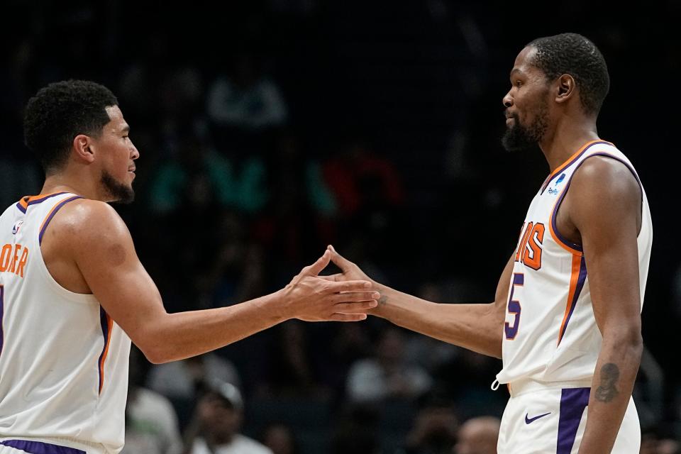 Phoenix Suns forward Kevin Durant celebrates after their win against the Charlotte Hornets with guard Devin Booker in an NBA basketball game on Wednesday, March 1, 2023, in Charlotte, N.C. (AP Photo/Chris Carlson)