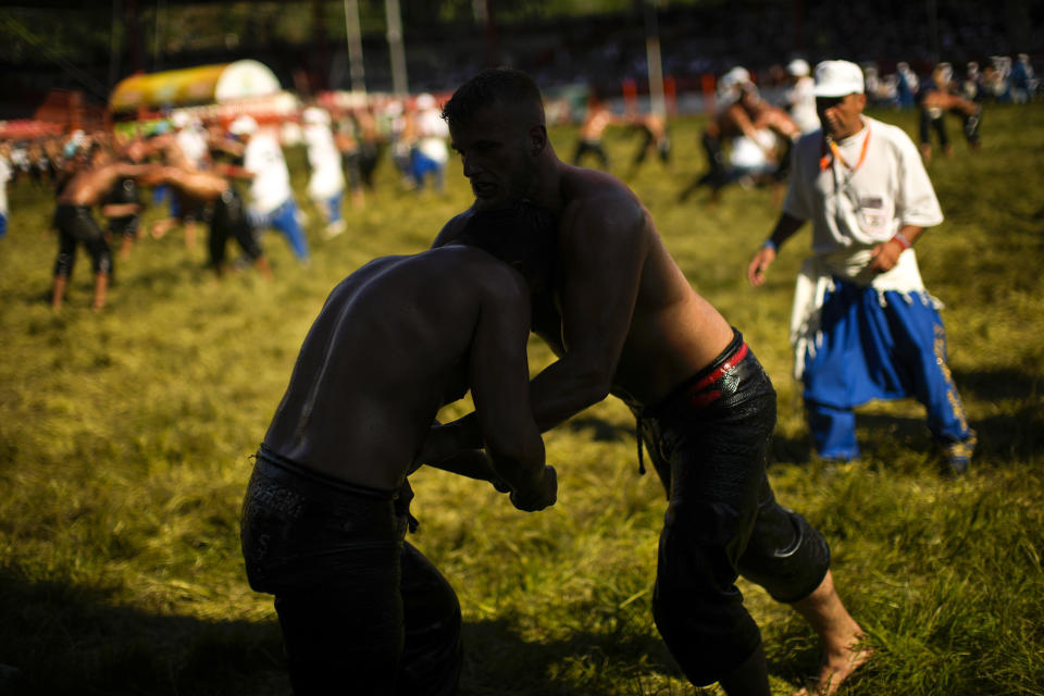 Wrestlers compete during the 661st annual Historic Kirkpinar Oil Wrestling championship, in Edirne, northwestern Turkey, Saturday, July 2, 2022. The festival is part of UNESCO's List of Intangible Cultural Heritages. (AP Photo/Francisco Seco)