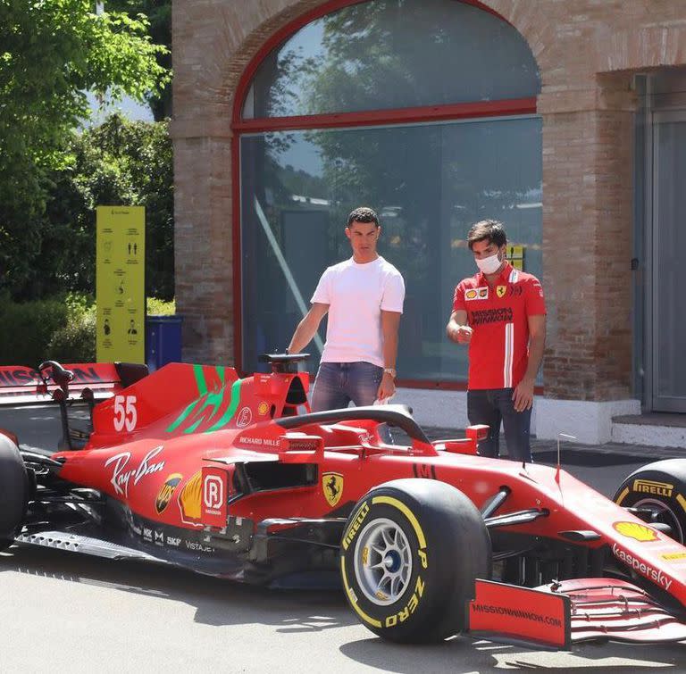 Cristiano y Carlos Sainz junto a la nave de Ferrari que compite en Fórmula 1