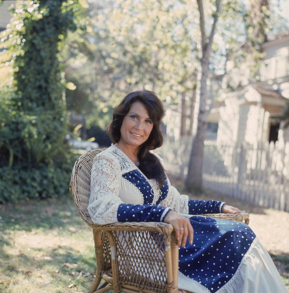 A woman sits in a chair outside