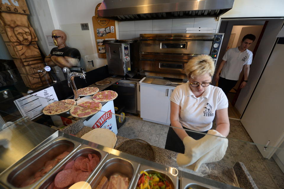 In this photo taken March 18, 2020, Bozena Legowska is making free pizzas for the doctors and medics of the Bielany hospital in Warsaw, Poland, as part of a nationwide action in a gesture of support for their unstopping fight against the spreading coronavirus. Restaurants and eateries remain closed to the public under a "national quarantine" aimed at breaking the human transmission belt for the virus, but they can do deliveries. (AP Photo/Czarek Sokolowski)