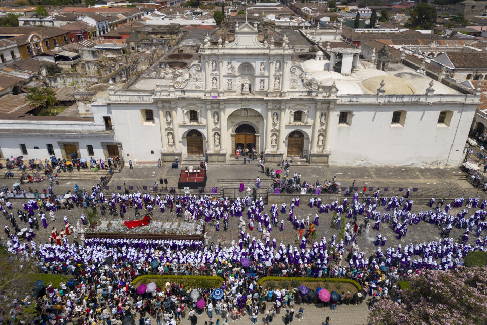 Penitentes llamados cucuruchos cargan una carroza con una estatua de Jesucristo con su cruz durante una procesión de Semana Santa frente a la catedral de San José, en Antigua, Guatemala, el Viernes Santo, 29 de marzo de 2024. (AP Foto/Moisés Castillo)