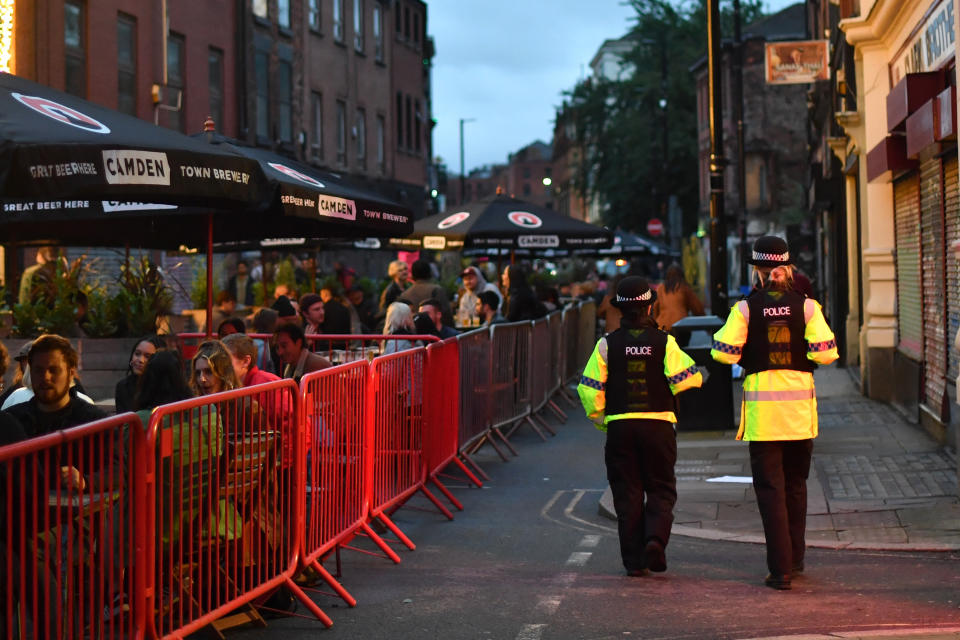 MANCHESTER, ENGLAND - JULY 04: Police officers patrol as bars on Thomas Street in the Northern Quarter set out tables for customers on the closed road on July 04, 2020 in Manchester, England. The UK Government announced that Pubs, Hotels and Restaurants can open from Saturday, July 4th providing they follow guidelines on social distancing and sanitising.  (Photo by Anthony Devlin/Getty Images)