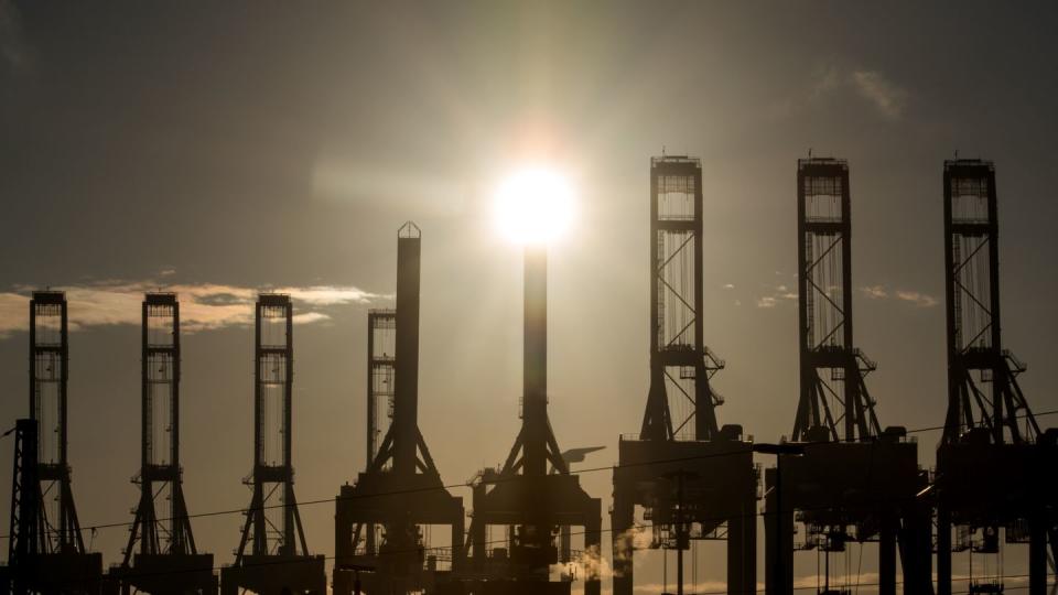 Die Sonne scheint hinter den Kränen des Containerterminals Burchardkai in Hamburg.(Archivbild)