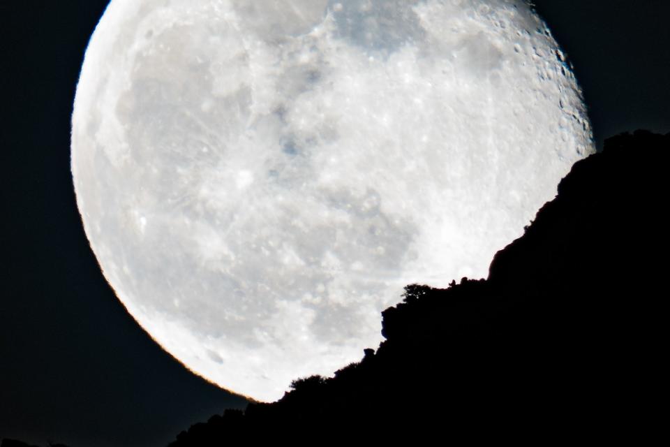 A Beaver Moon rises above a rocky canyon wall in Dinosaur National Monument, on the border between Colorado and Utah.