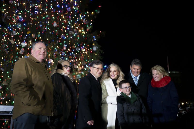 (L-R) Rep. Alexander Mooney, R-WV, Rep. Carol Miller, R-WV, Speaker of the House Mike Johnson, R-LA and his wife, Kelly, Ethan Reese, the youth tree lighter from West Virginia, Sen. Joe Manchin, D-WV, and Sen. Shelly Moore Capito, R-WV, stand for a picture in front of the 2023 Capitol Christmas Tree, a 63-foot Norway spruce from the Monongahela National Forest in West Virginia, after Tuesday's lighting ceremony at the U.S. Capitol in Washington, D.C. Photo by Bonnie Cash/UPI.