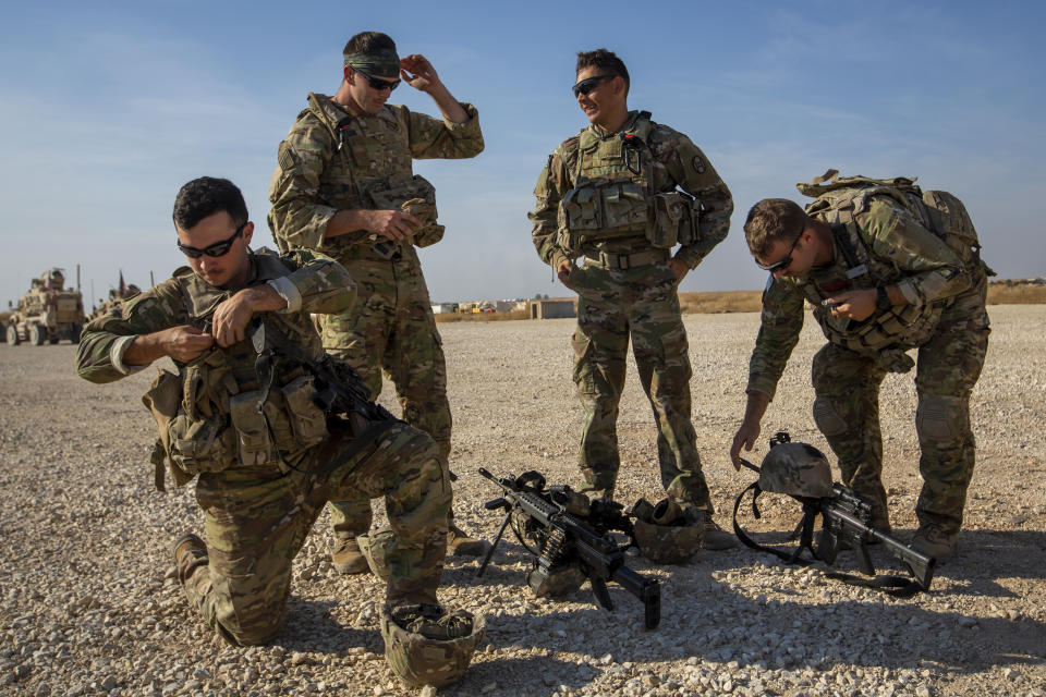 Crewmen rest their weapons after training with Bradley fighting vehicles at a US military base at undisclosed location in Northeastern Syria, Monday, Nov. 11, 2019. The deployment of the mechanized force comes after US troops withdrew from northeastern Syria, making way for a Turkish offensive that began last month. (AP Photo/Darko Bandic)