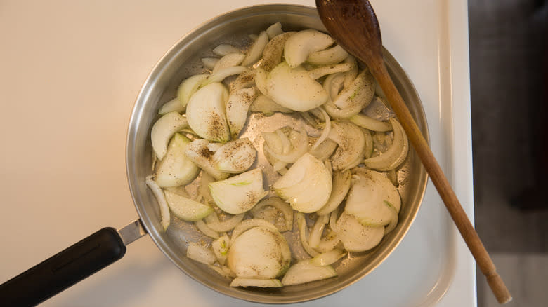 sliced onions in stovetop skillet 