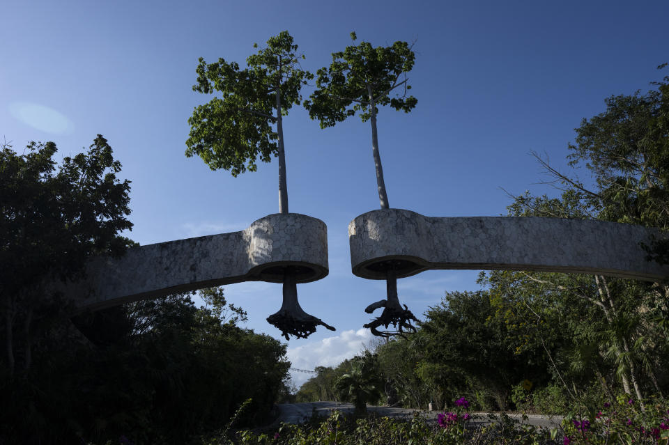 Trees with exposed roots are suspended as decoration at the entrance of a tourist complex in Playa del Carmen, Mexico, Thursday, March 7, 2024. Once a Mayan settlement, the city is among many in the Yucatan Peninsula that in recent decades have been converted into a party hub for vacationing foreigners. (AP Photo/Rodrigo Abd)