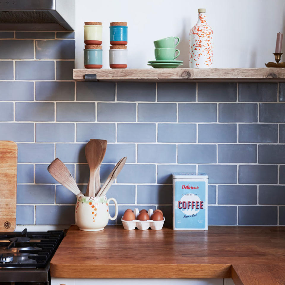 kitchen with metro tiles and wooden worktop with egg tray