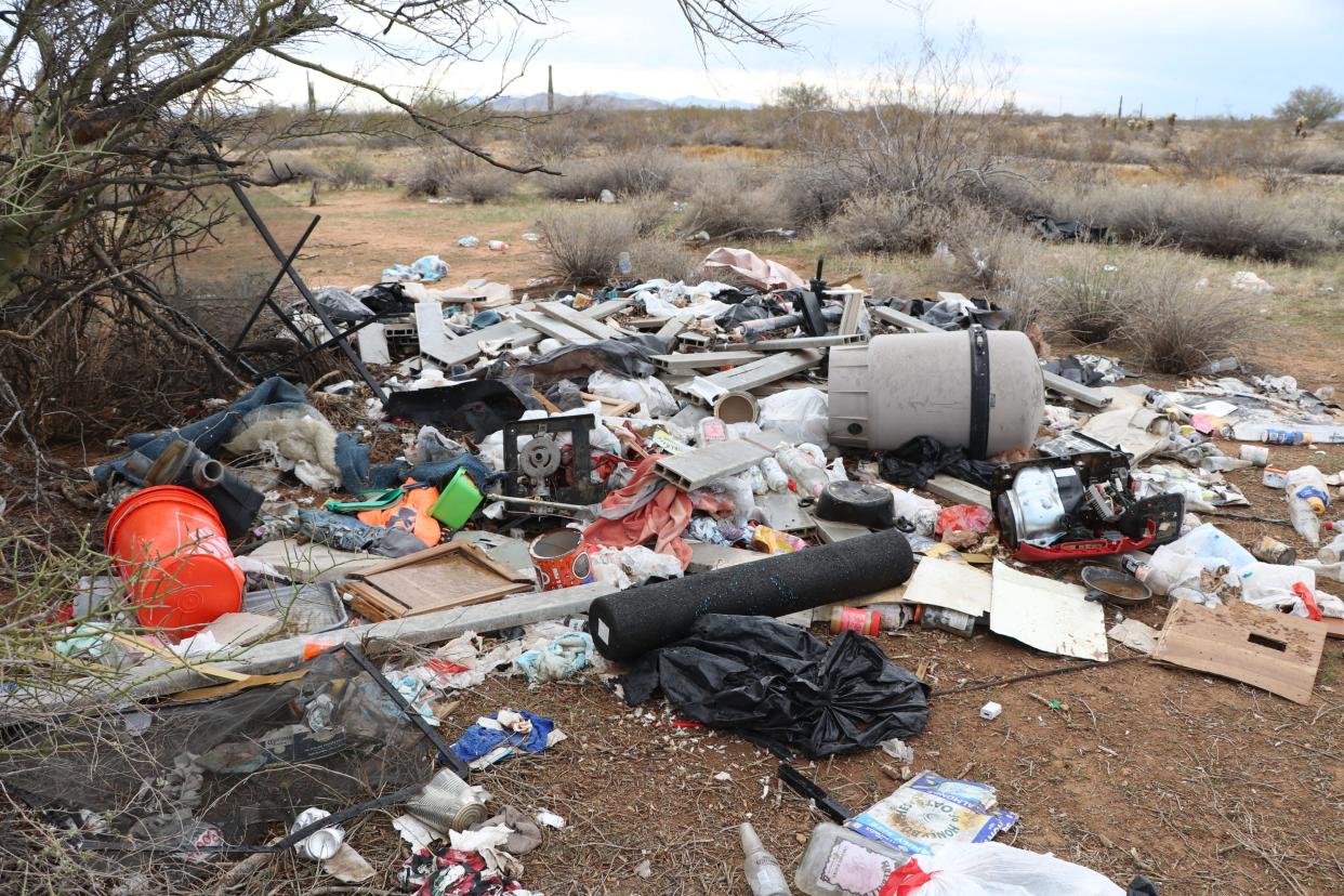 A trash pile containing coolers, buckets, bottles and other debris litter a portion of the desert on Arizona State Trust Land in the north Valley, near New River Road and Carefree Highway.
