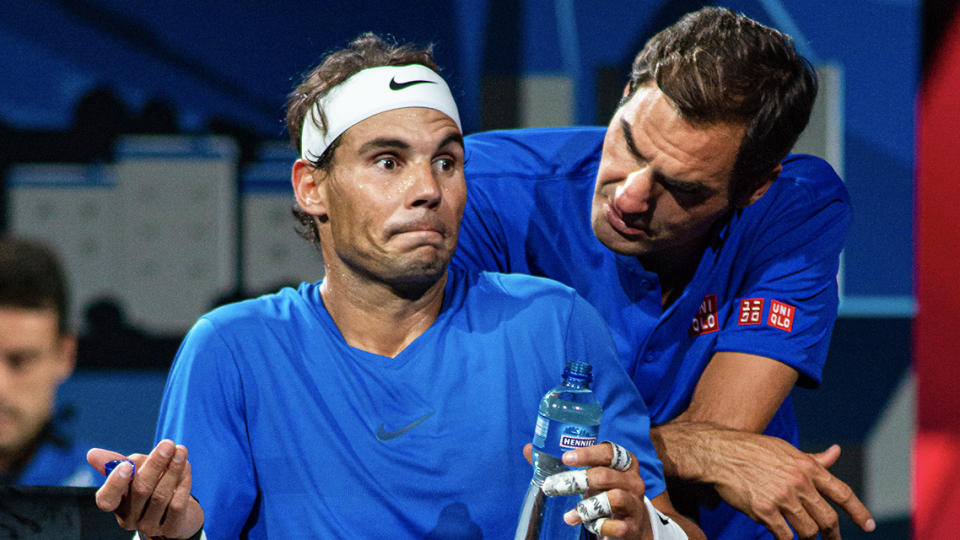 Rafael Nadal shrugs as he takes advice from Roger Federer.