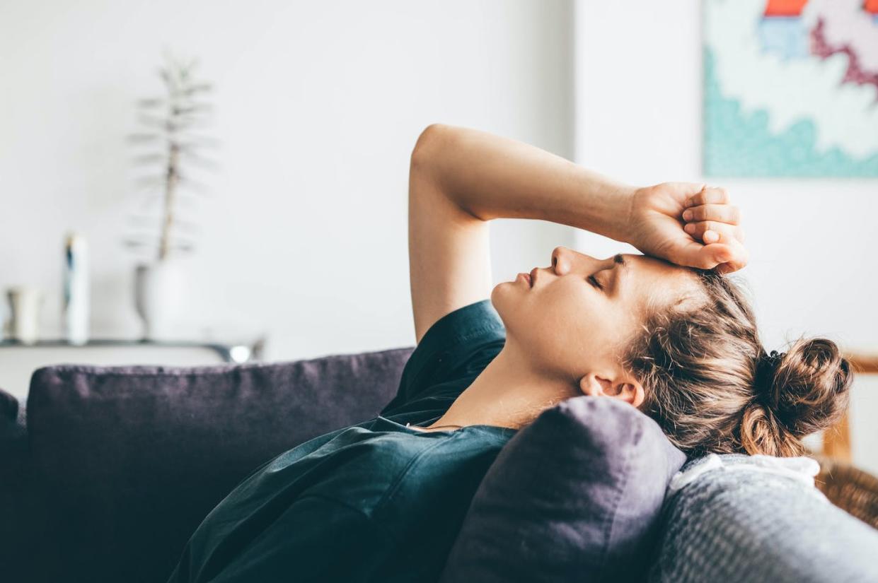 About 10% of COVID-19 patients will experience continuing symptoms for 12 weeks or more following diagnosis. <a href="https://www.gettyimages.com/detail/photo/sad-and-depressed-woman-sitting-on-sofa-at-home-royalty-free-image/1403986369?phrase=Woman%20sleeping%20on%20couch&adppopup=true" rel="nofollow noopener" target="_blank" data-ylk="slk:Maria Korneeva/Moment via Getty Images;elm:context_link;itc:0;sec:content-canvas" class="link ">Maria Korneeva/Moment via Getty Images</a>