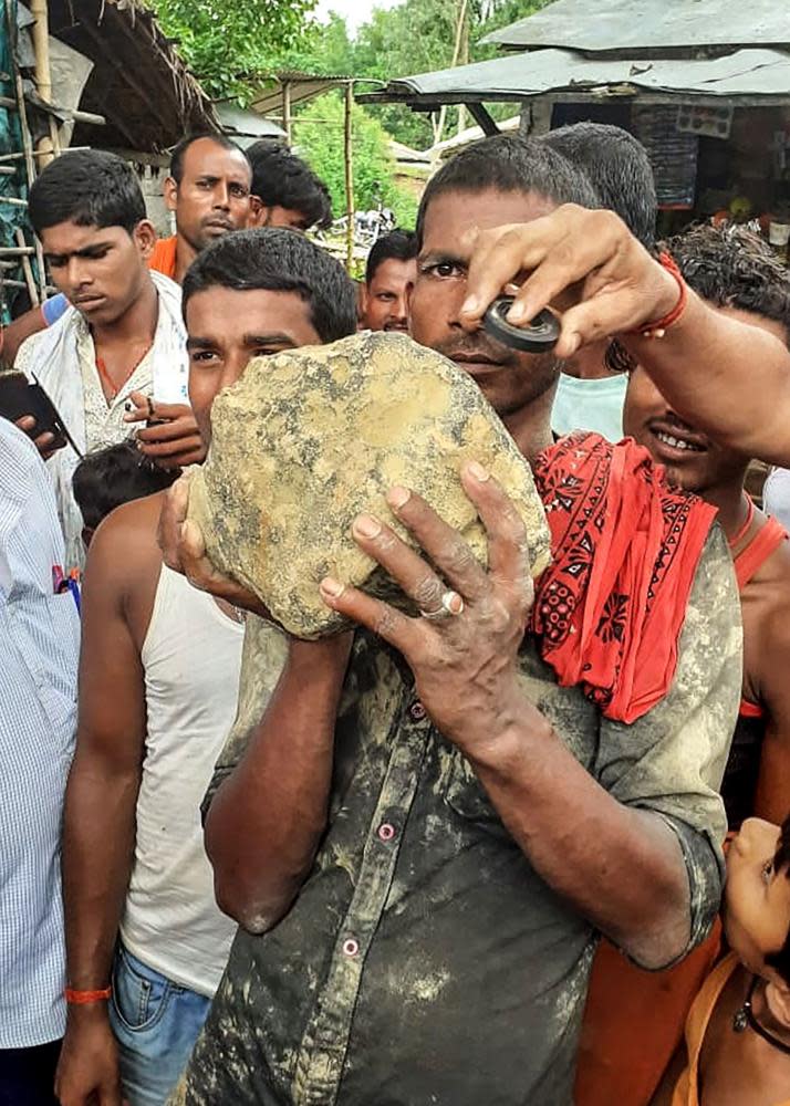 A villager holds the suspected meteorite.
