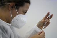 A military nurse prepares a dose of the Pfizer coronavirus vaccine at a vaccination center in Lisbon, Tuesday, Sept. 21, 2021. As Portugal nears its goal of fully vaccinating 85% of the population against COVID-19 in nine months, other countries want to know how it was able to accomplish the feat. A lot of the credit is going to Rear Adm. Henrique Gouveia e Melo. (AP Photo/Armando Franca)