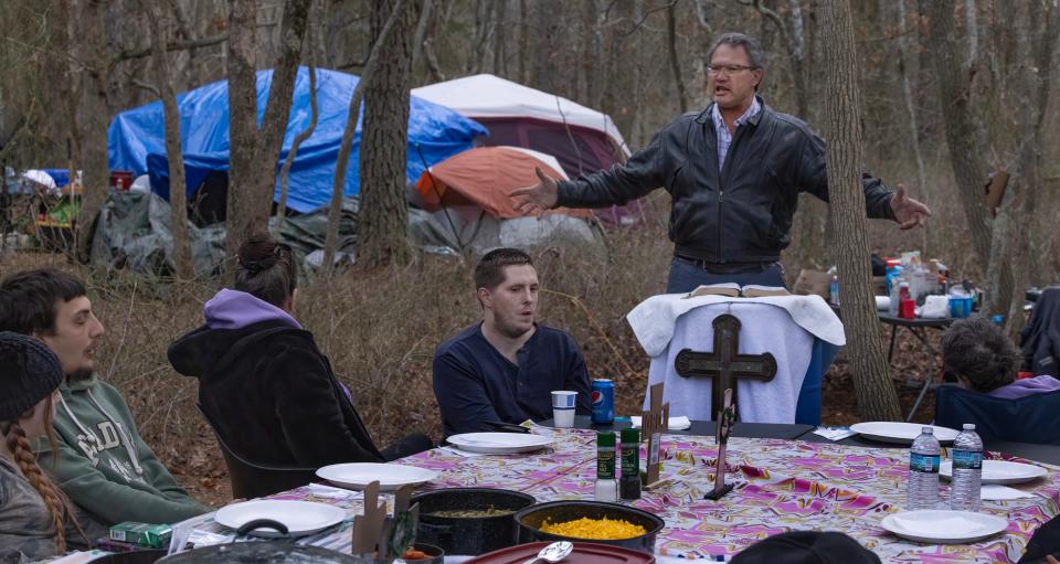 Rev. Steve Brigham delivers an Easter sermon and prayer before the homeless enjoy their Easter dinner at a camp in the woods of Toms River.