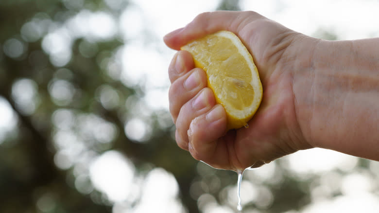 hand squeezing a lemon