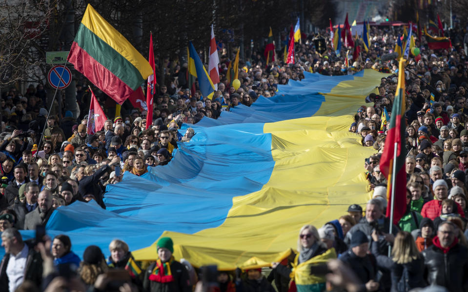People carry a giant Ukrainian flag to protest against the Russian invasion of Ukraine during a celebration of Lithuania's independence in Vilnius, Lithuania, Friday, March 11, 2022. Lithuania celebrated the 32th anniversary of its declaration of independence from the Soviet Union on Friday, recalling the seminal events that set the Baltic nation on a path to freedom and helped lead to the collapse of the U.S.S.R. (AP Photo/Mindaugas Kulbis)
