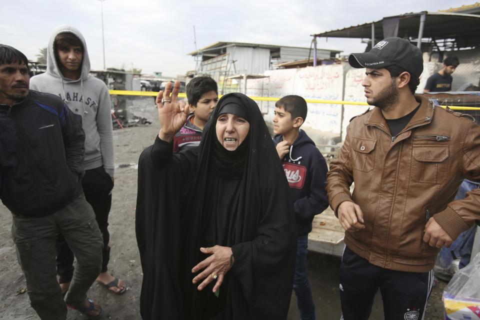 An Iraqi woman looks at damages from a car bomb explosion at a crowded outdoor market in the Iraqi capital's eastern district of Sadr City, Iraq, Monday, Jan 2, 2017. A suicide bomber blew up his explosives-laden vehicle Monday in a bustling market area in Baghdad, killing more than a dozen people, Iraqi officials said, hours after the arrival of French President Francois Hollande to the country and amid a fierce fight against the Islamic State group. (AP Photo/ Karim Kadim)