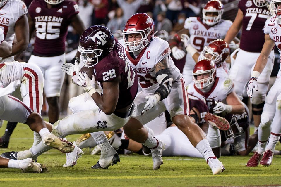 Texas A&M running back Isaiah Spiller (28) rushes for a touchdown as Arkansas linebacker Grant Morgan (31) tries to make a tackle during their game in 2020 in College Station, Texas.