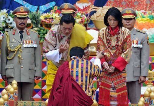 King of Bhutan Jigme Khesar Namgyel Wangchuck (L) and future queen Jetsun Pema stand together during their marriage ceremony in the main courtyard of the 17th-century fortified monastery or dzong in Punakha on October 13, 2011. Bhutan's 31-year-old king married a student 10 years his junior in an isolated valley high in the Himalayas