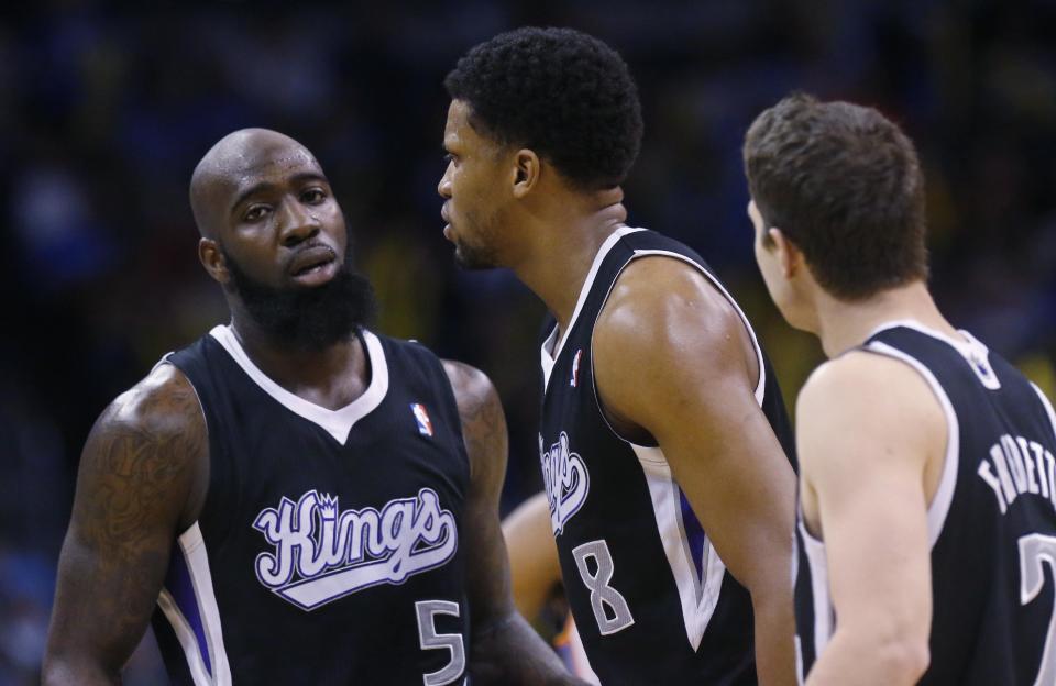 Sacramento Kings forward Rudy Gay (8) is surrounded by teammates forward Quincy Acy (5) and guard Jimmer Fredette (7) after being ejected from the game in the fourth quarter of an NBA basketball game against the Oklahoma City Thunder in Oklahoma City, Sunday, Jan. 19, 2014. Oklahoma City won 108-93. (AP Photo/Sue Ogrocki)