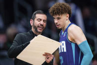 Charlotte Hornets head coach James Borrego, left, talks with guard LaMelo Ball, right, before an NBA basketball game against the Boston Celtics in Charlotte, N.C., Monday, Oct. 25, 2021. (AP Photo/Jacob Kupferman)