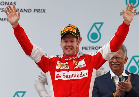 Formula One - F1 - Malaysian Grand Prix 2015 - Sepang International Circuit, Kuala Lumpur, Malaysia - 29/3/15 Ferrari's Sebastian Vettel celebrates winning the Malaysian Grand Prix on the podium Reuters / Olivia Harris