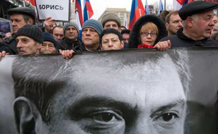 Russian opposition supporters carrying a banner bearing a portrait of Kremlin critic Boris Nemtsov march in central Moscow last year shortly after his killing