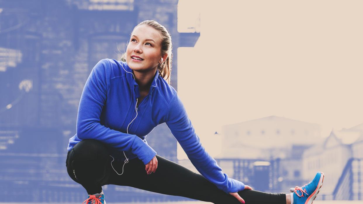 Woman wearing colorful athletic clothes stretching outside before a run