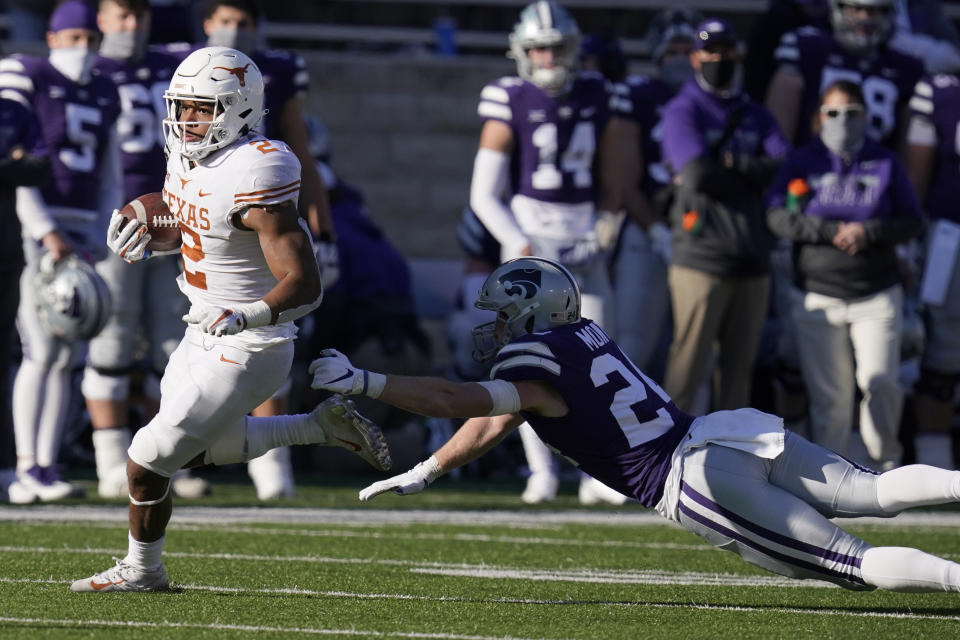 Texas running back Roschon Johnson (2) gets past Kansas State defensive back Brock Monty (24) during the second half of an NCAA college football game in Manhattan, Kan., Saturday, Dec. 5, 2020. (AP Photo/Orlin Wagner)